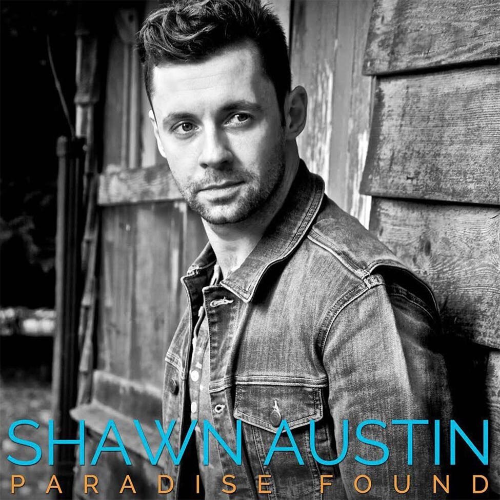 Single Cover Title Paradise Found Artist Shawn Austin black and white portrait standing against testured wood wall of barn looking past camera
