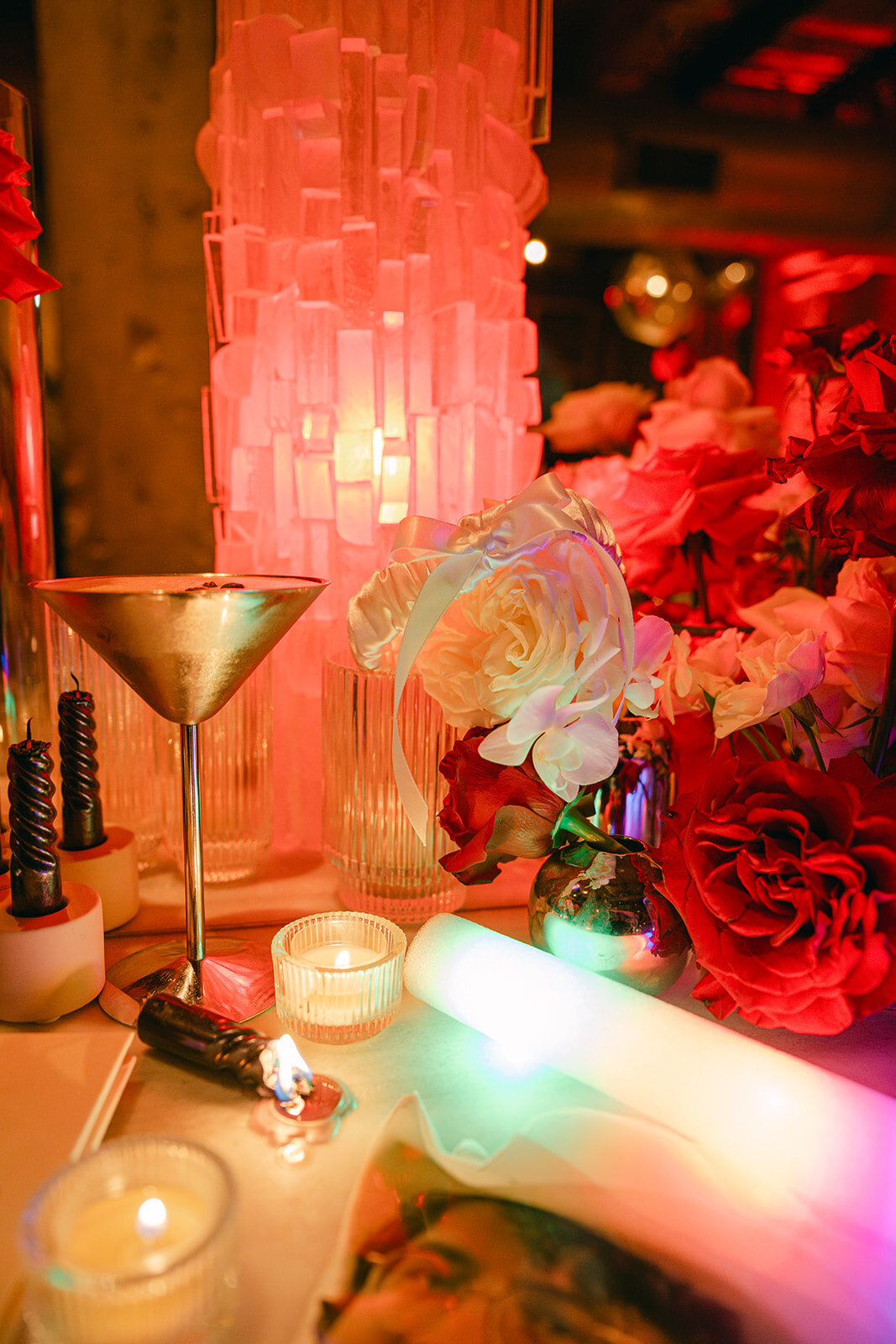 Close-up of opulent red and blush florals paired with soft candlelight at high-end Texas wedding