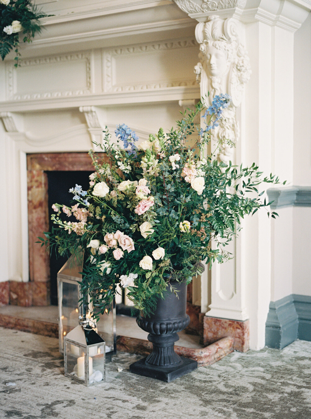 large floor flower arrangement by the fireplace with blue colour blooms