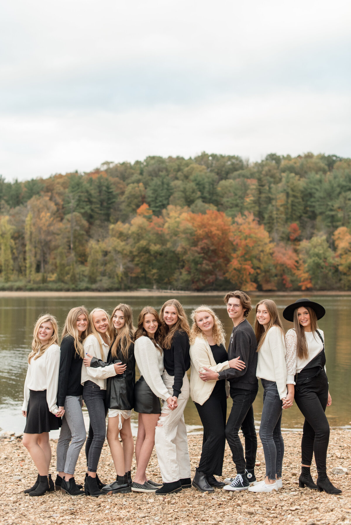 Ten Senior spokesmodels huddled together wearing black and white by lake in York, Pennsylvania on Fall day.