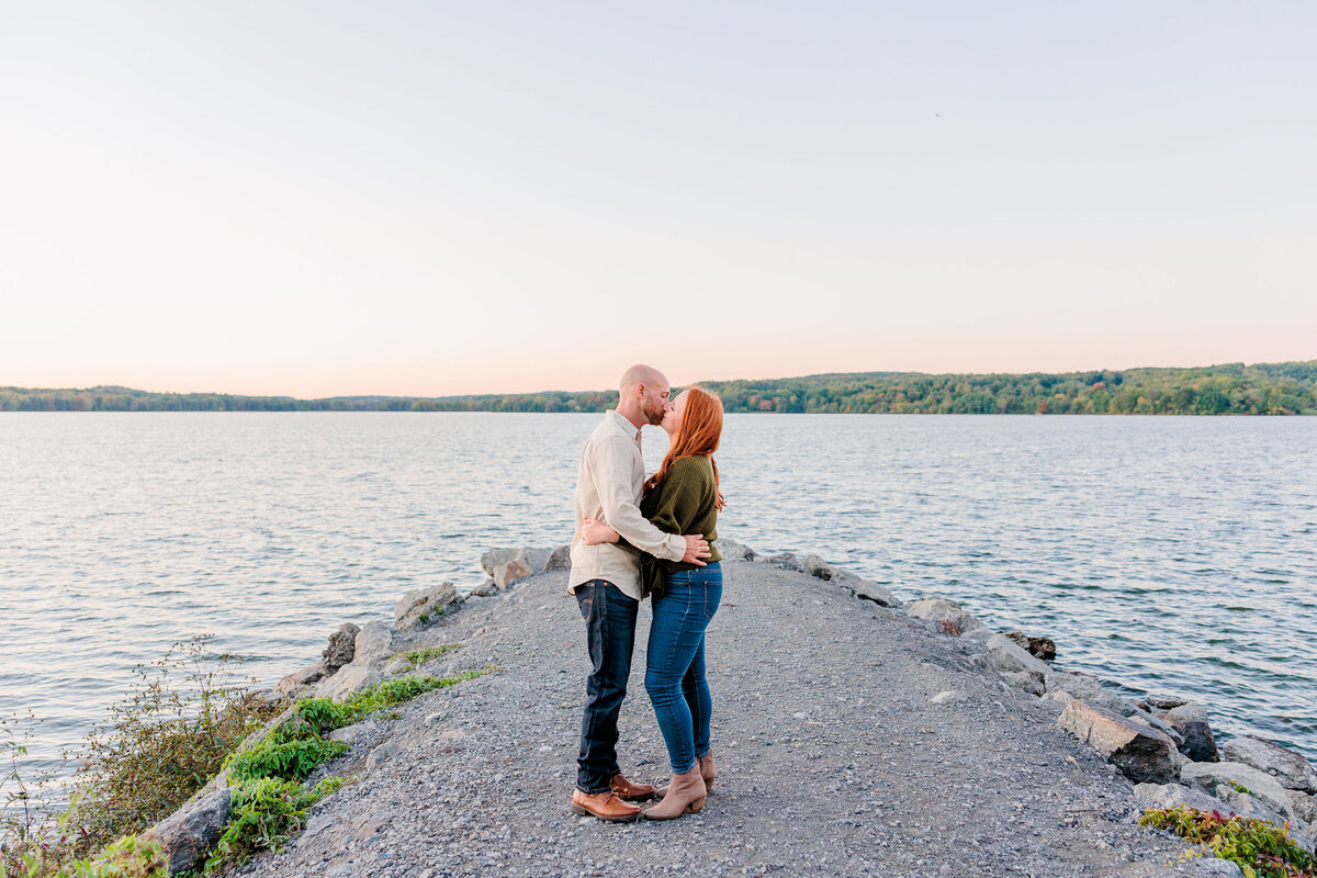 Golden hour engagement session along the lakeside with autumn leaves