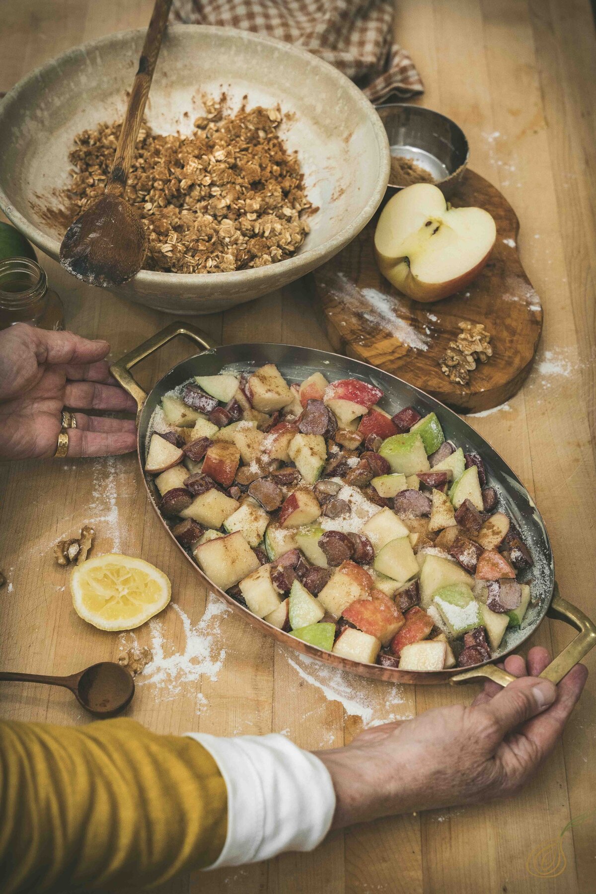 A woman is engaged in preparing a delicious dish featuring apples and an assortment of other ingredients.