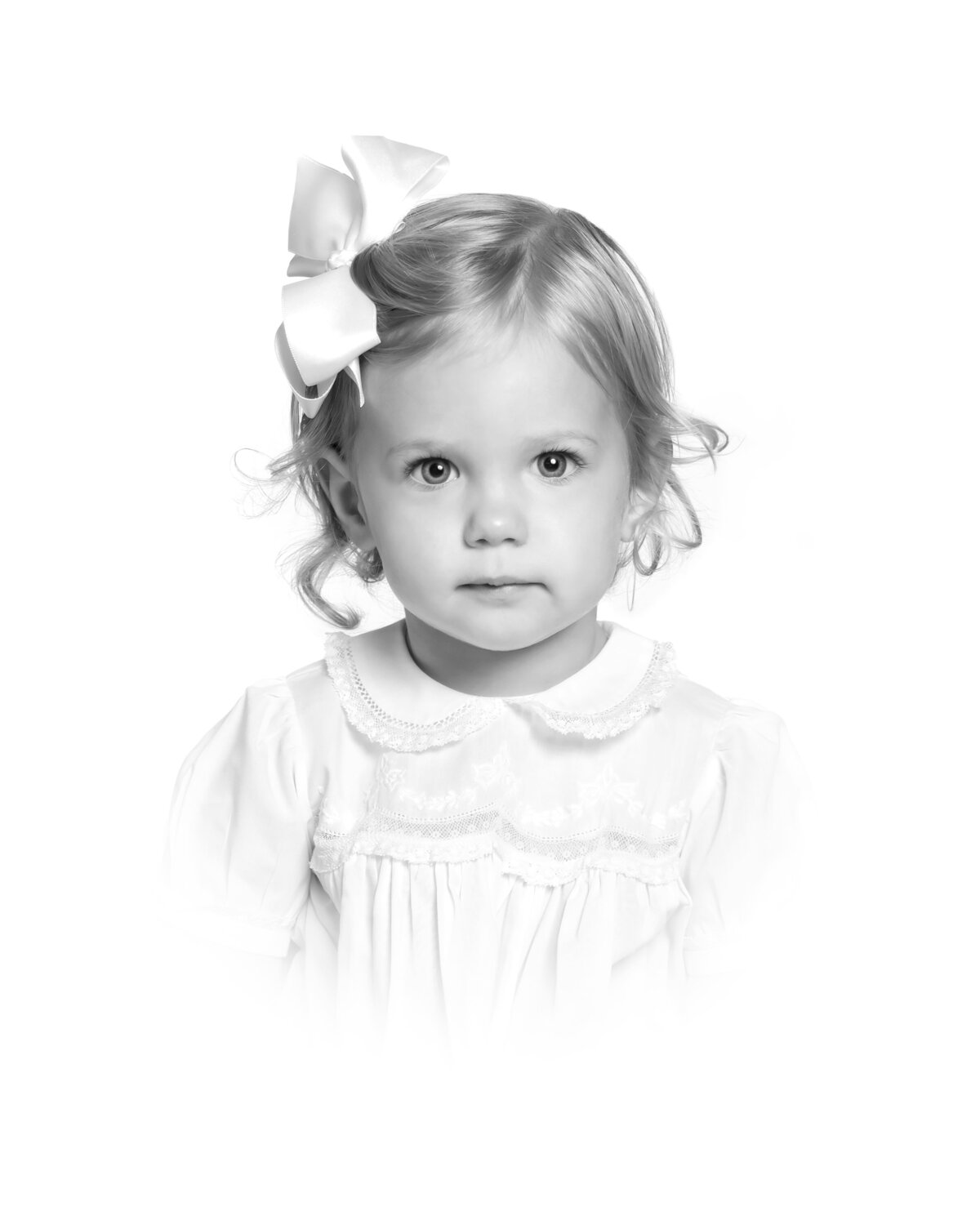 Timeless heirloom portrait of a young girl in a white vintage dress, captured with studio lighting against a classic white backdrop.