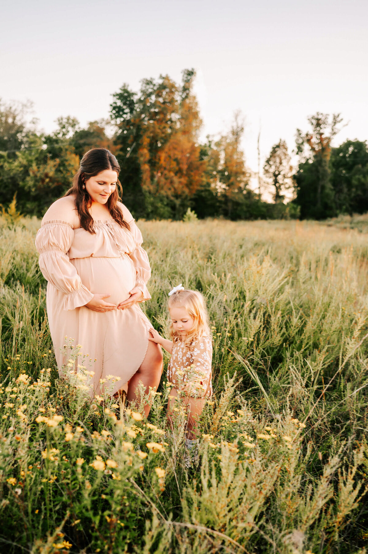 Joplin MO maternity photographer Jessica Kennedy of The XO Photography captures pregnant mom and toddler picking flowers in a field