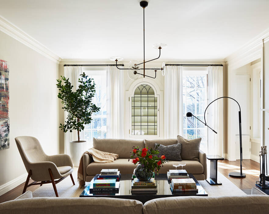 Modern living room design in a historic home by a top interior designer in Boston, blending classic details with contemporary furnishings.
