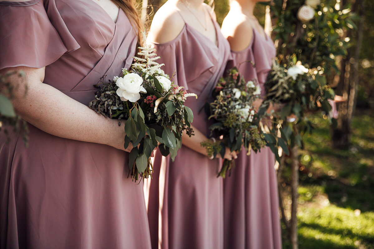 mauve bridesmaids dresses holding heavy greenery bridesmaid bouquets