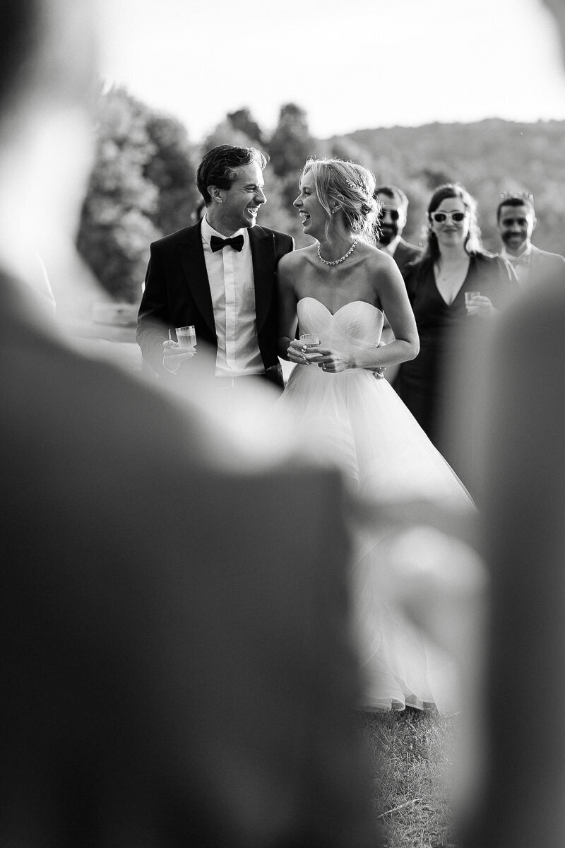 Deux mariées rient ensemble lors d'un discours pendant leur cocktail au mariage. 