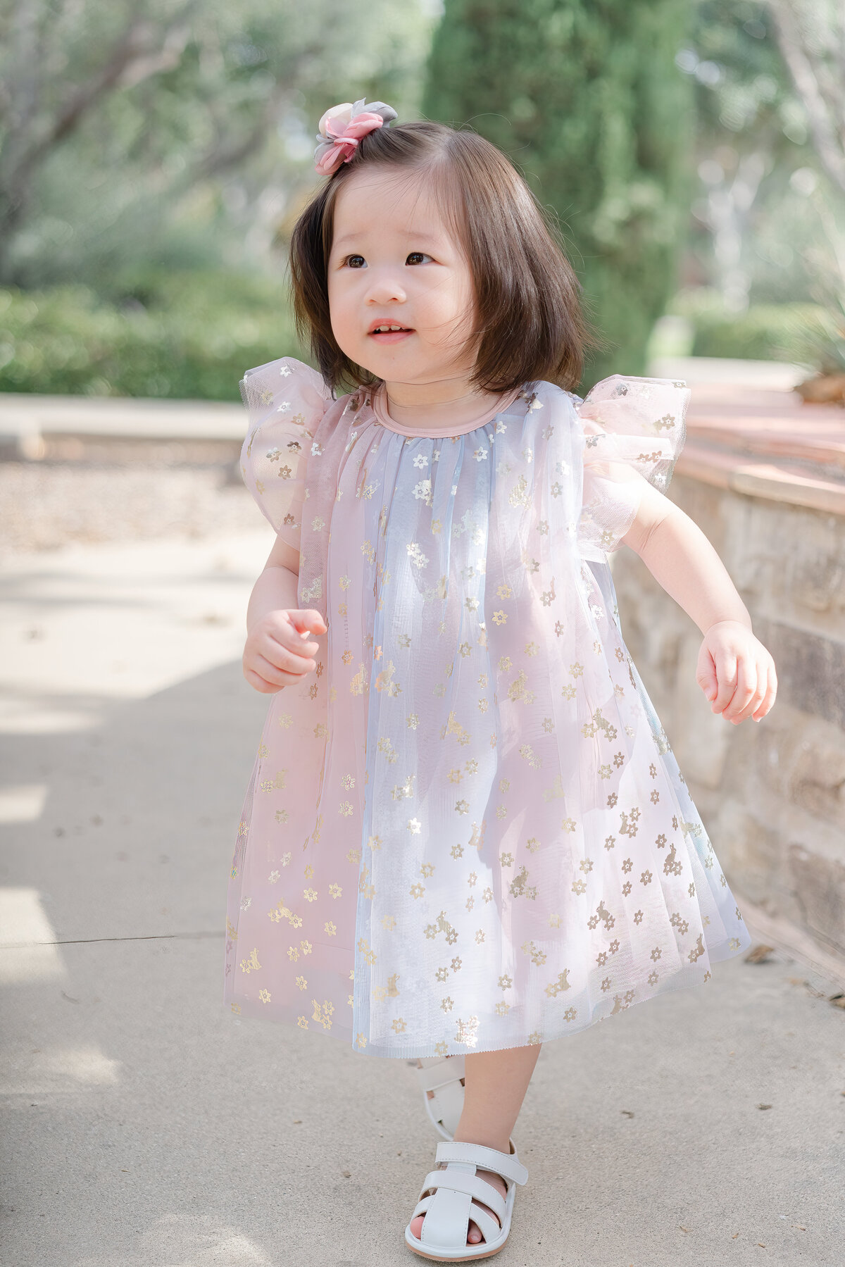 little girl wearing dress walking in orange county park