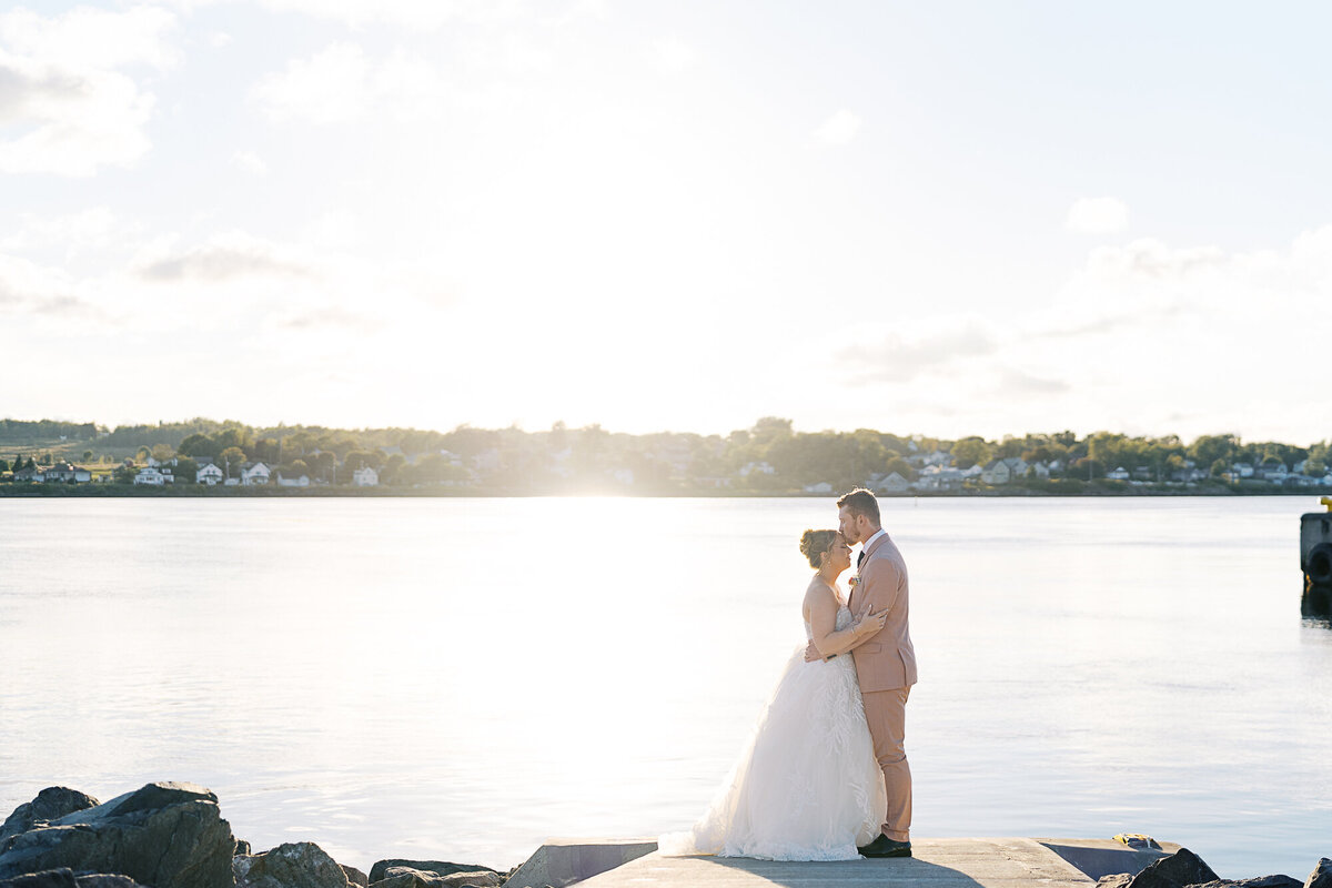 bride and groom in front of ocean at golden hour