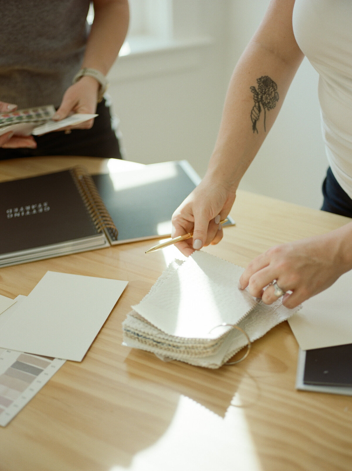 woman with flower tattoo examines creative color swatches for a film branding product photoshoot