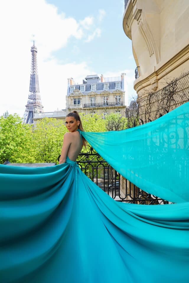 women having a portrait photoshoot in paris wearing a blue flying dress