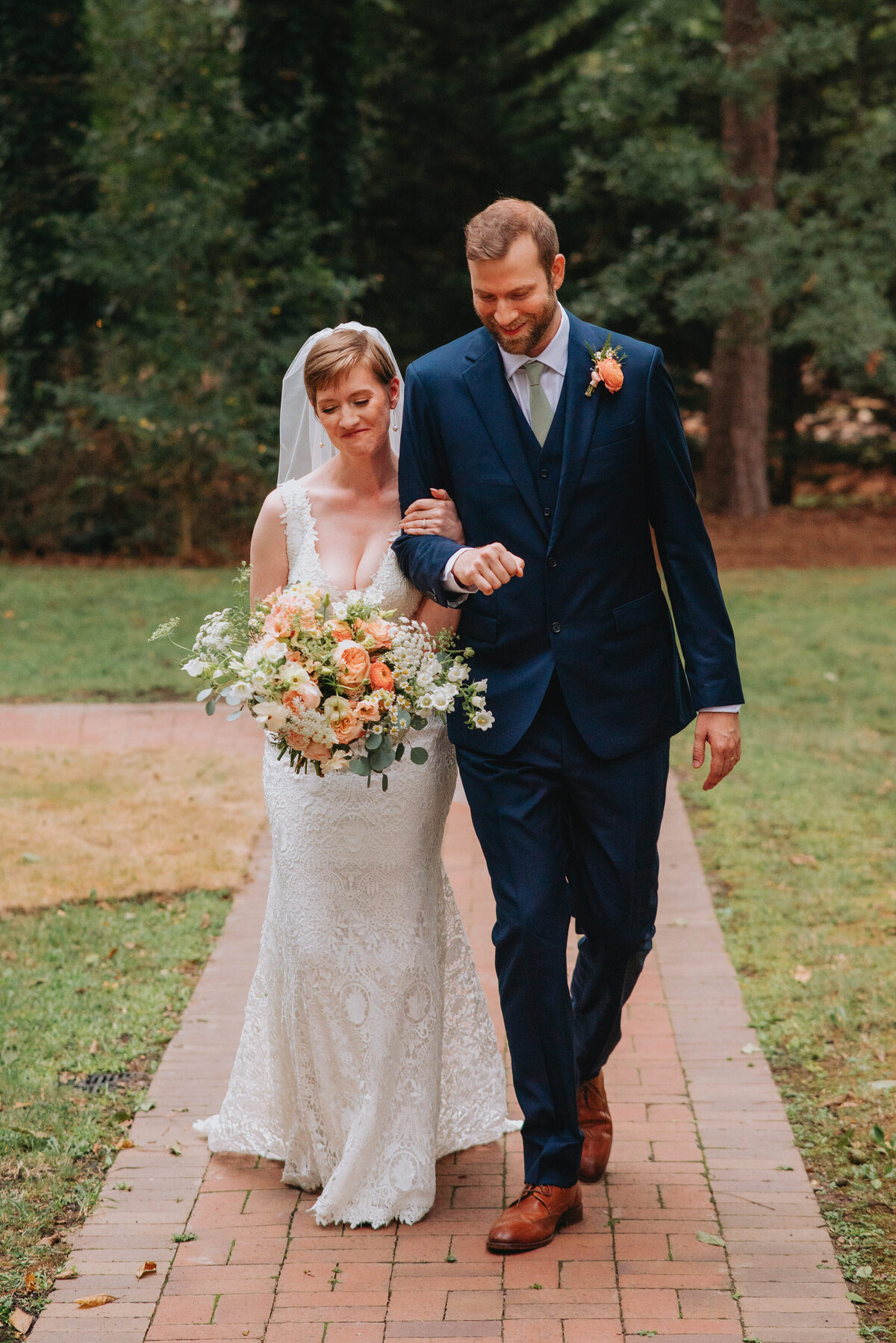 Newlyweds hold one another, smiling, as they walk
