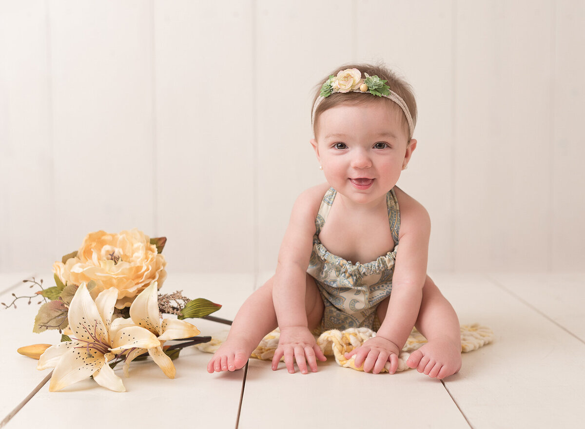 Sitting baby with flower capture by Laura King