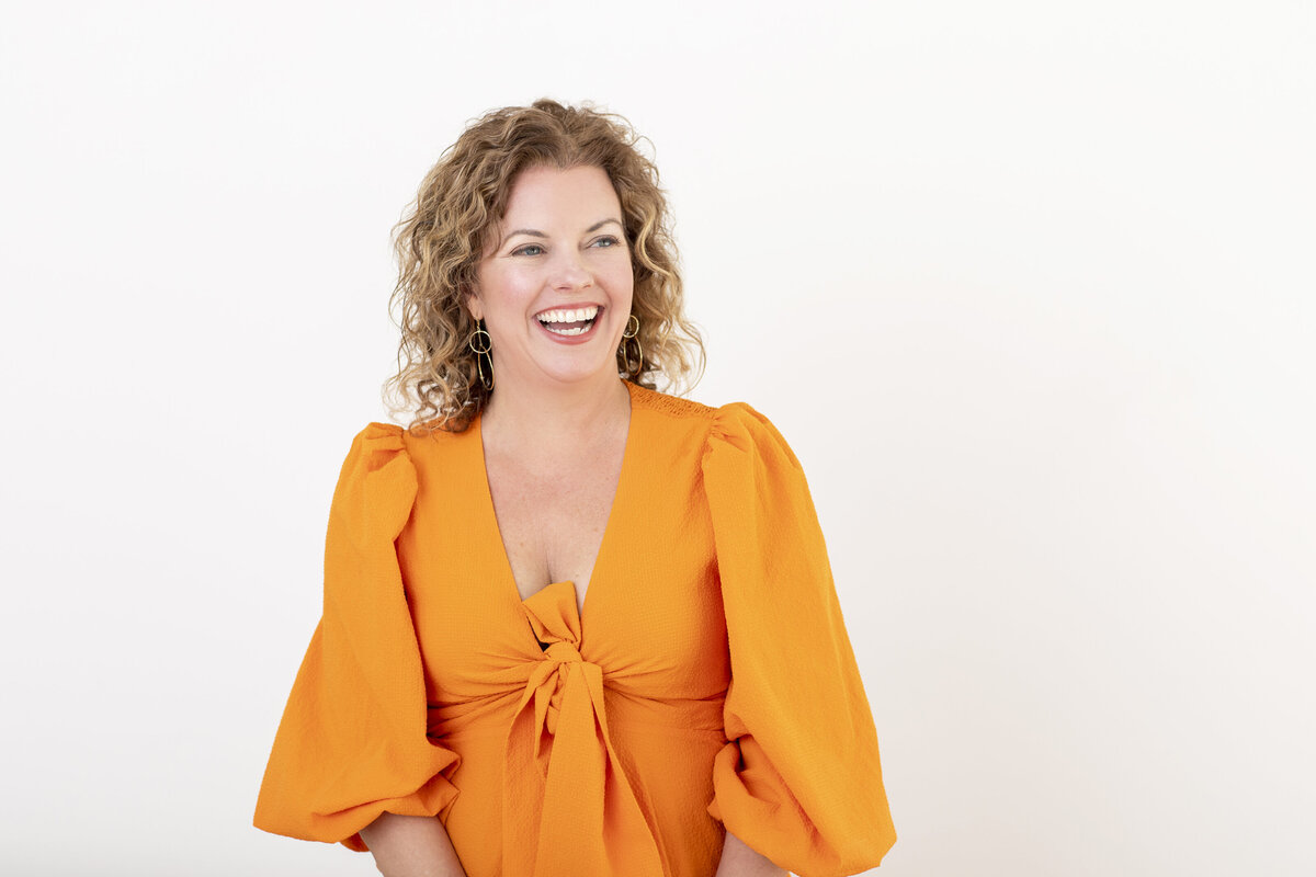 Woman wearing a bright orange dress for a modern Philadelphia headshot