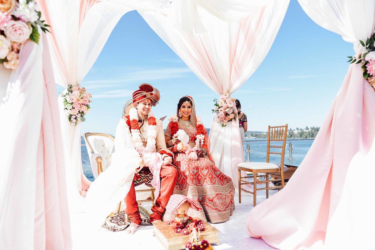 Vibrant coral, peach and red Indian wedding ceremony on lake Washington  in Seattle.