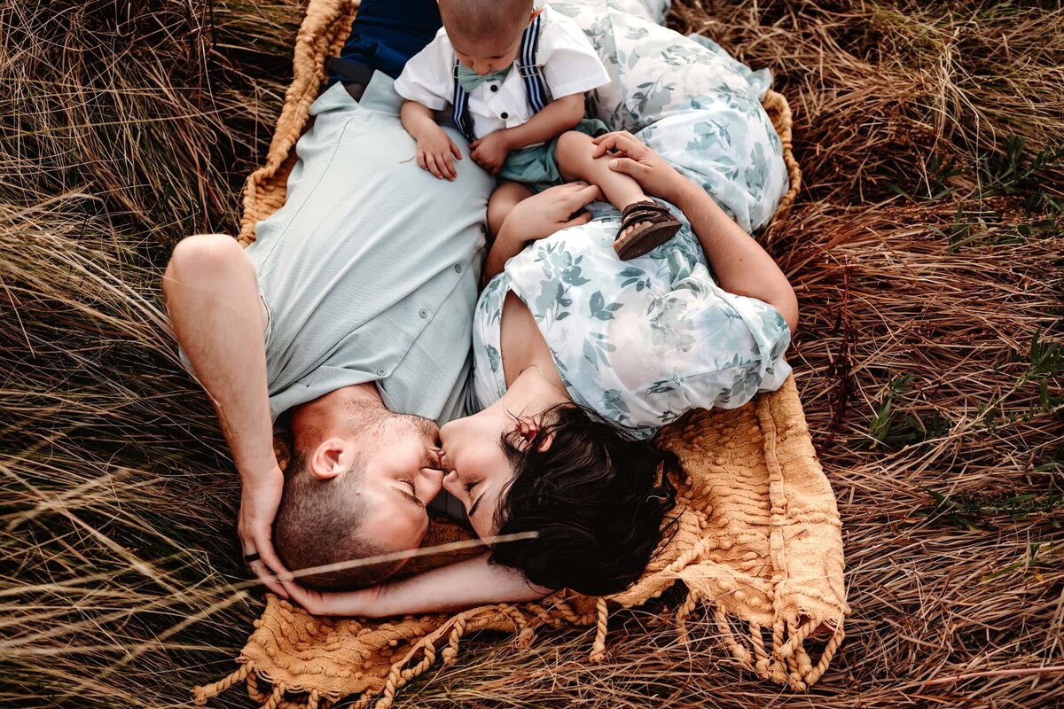 San Diego Family Photographer captures couple laying in grass during outdoor family photos
