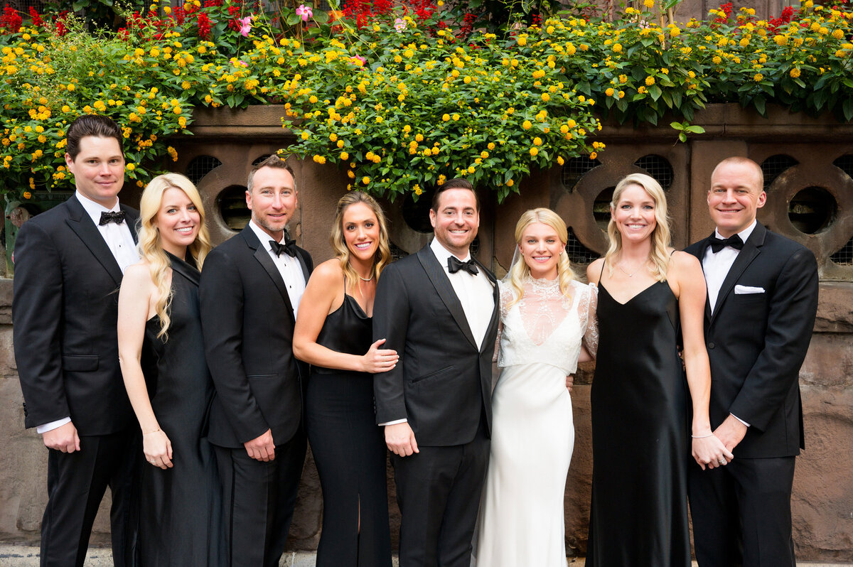 bride and groom taking photos with their wedding party