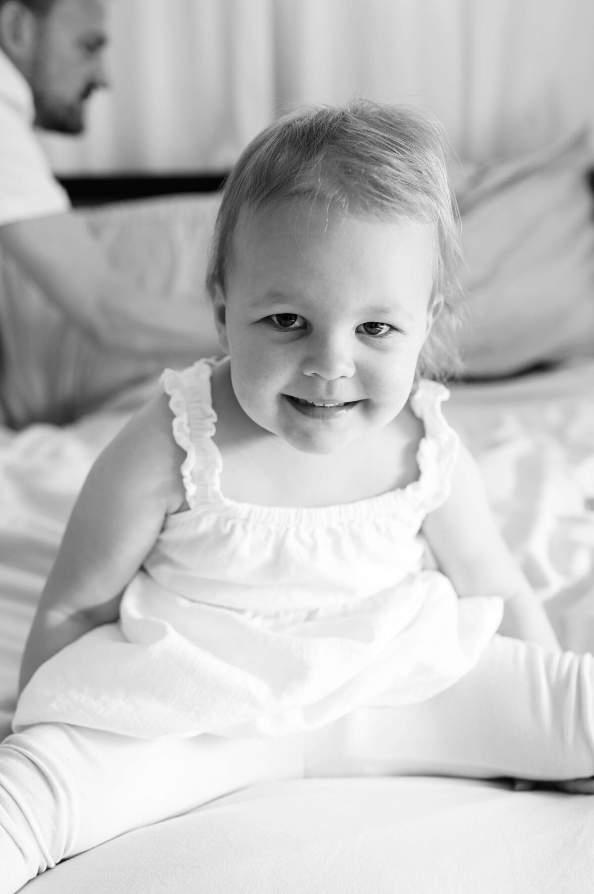 Virginia family photographer takes a cute black and white picture of a toddler smiling at the camera