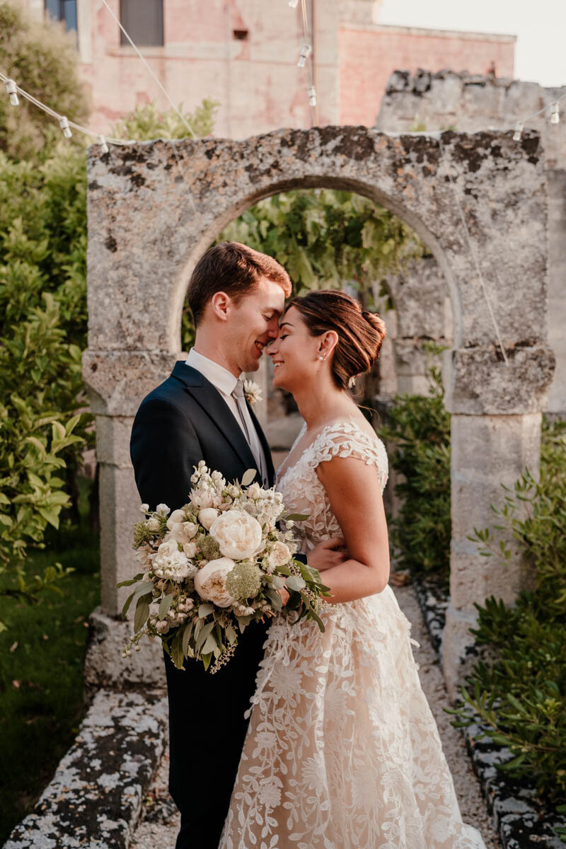 Séance photo de mariage dans les Pouilles à la Masseria Spina, un couple entre les murs les oliviers sous la lumière dorée.