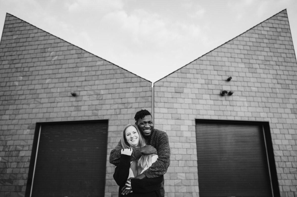 A couple stands in front of a boat house