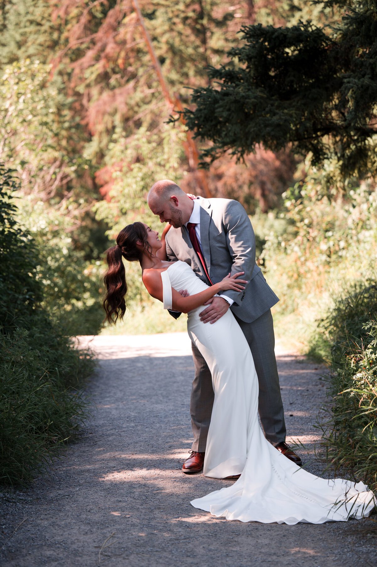 wedding couple kiss on path in Edmonton, Alberta park