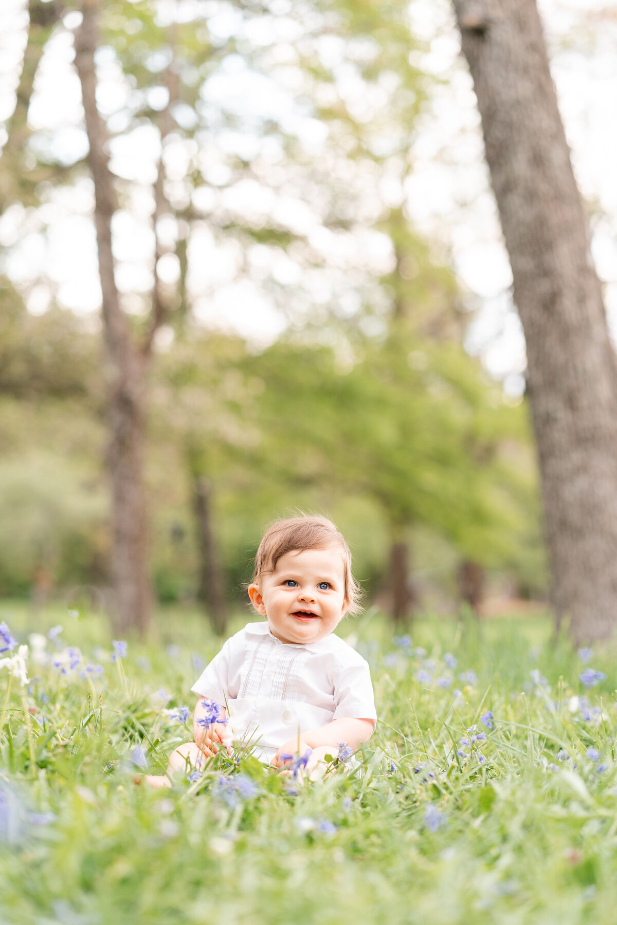 Photographer in Chattanooga, TN Kelley Hoagland takes photo of baby boy posing in seated in grass at McCoy Farms Signal Mountain photo location.