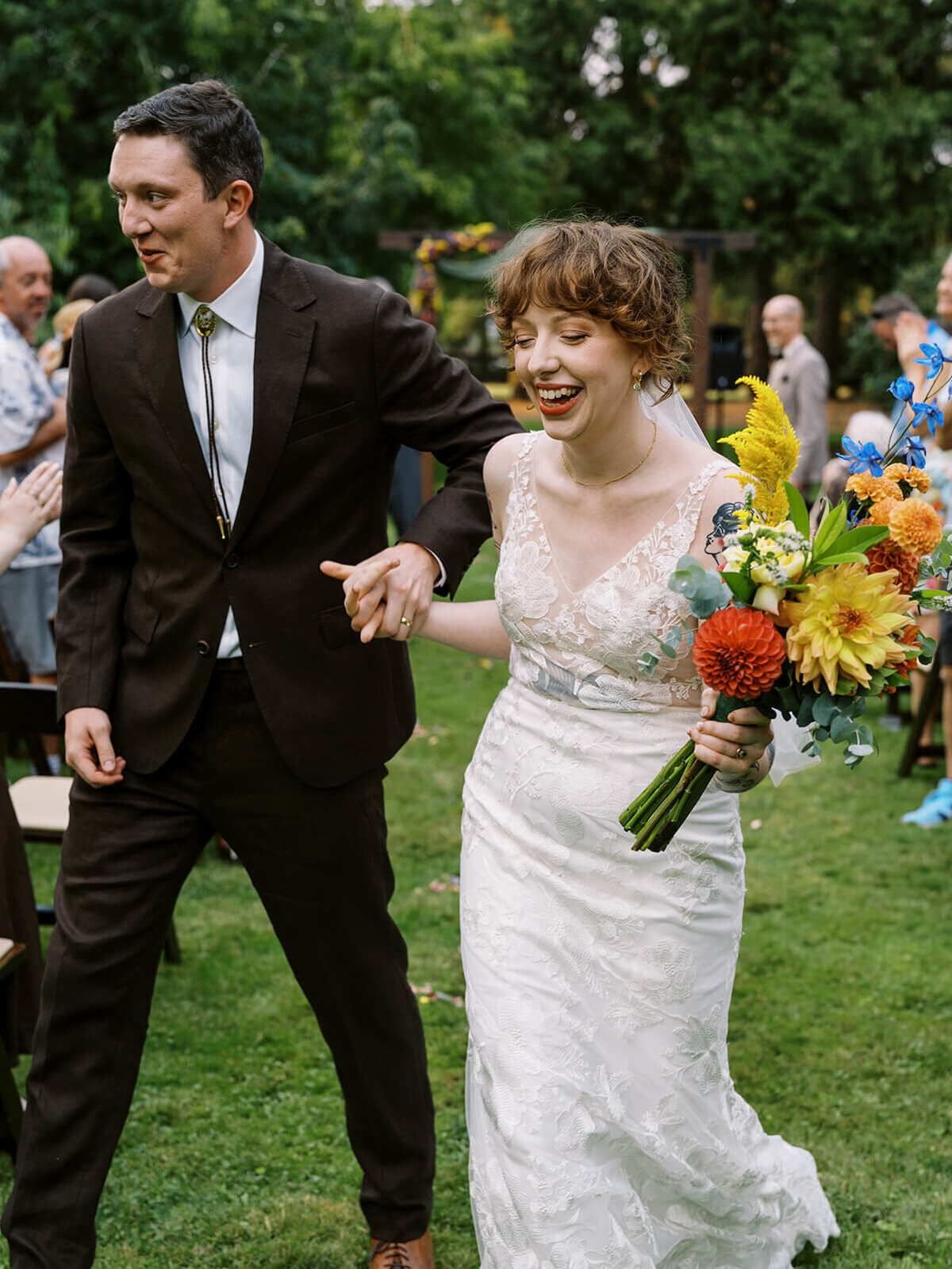 Bride and groom smiling and walking down the aisle. 