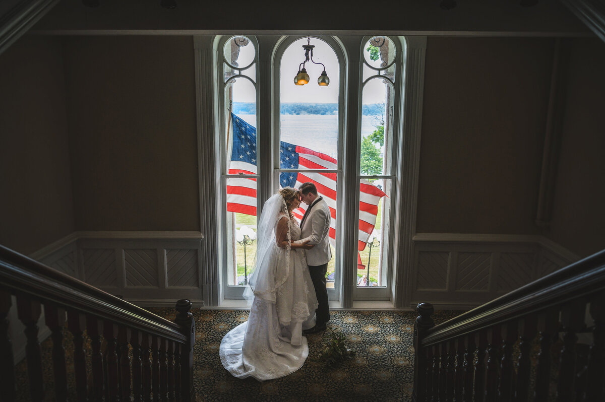 Bride and group at the Chautauqua Institution with an American Flag flying in the background.