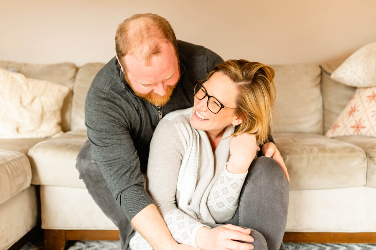 Couple laughing in their home during a couples session near Naperville, IL.