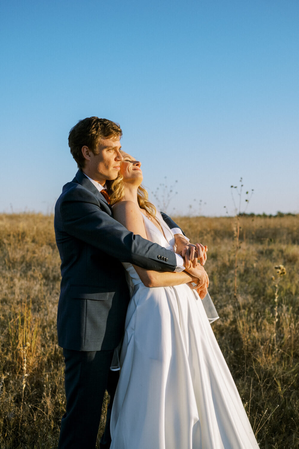 bride-relaxed-into-grooms-embrace