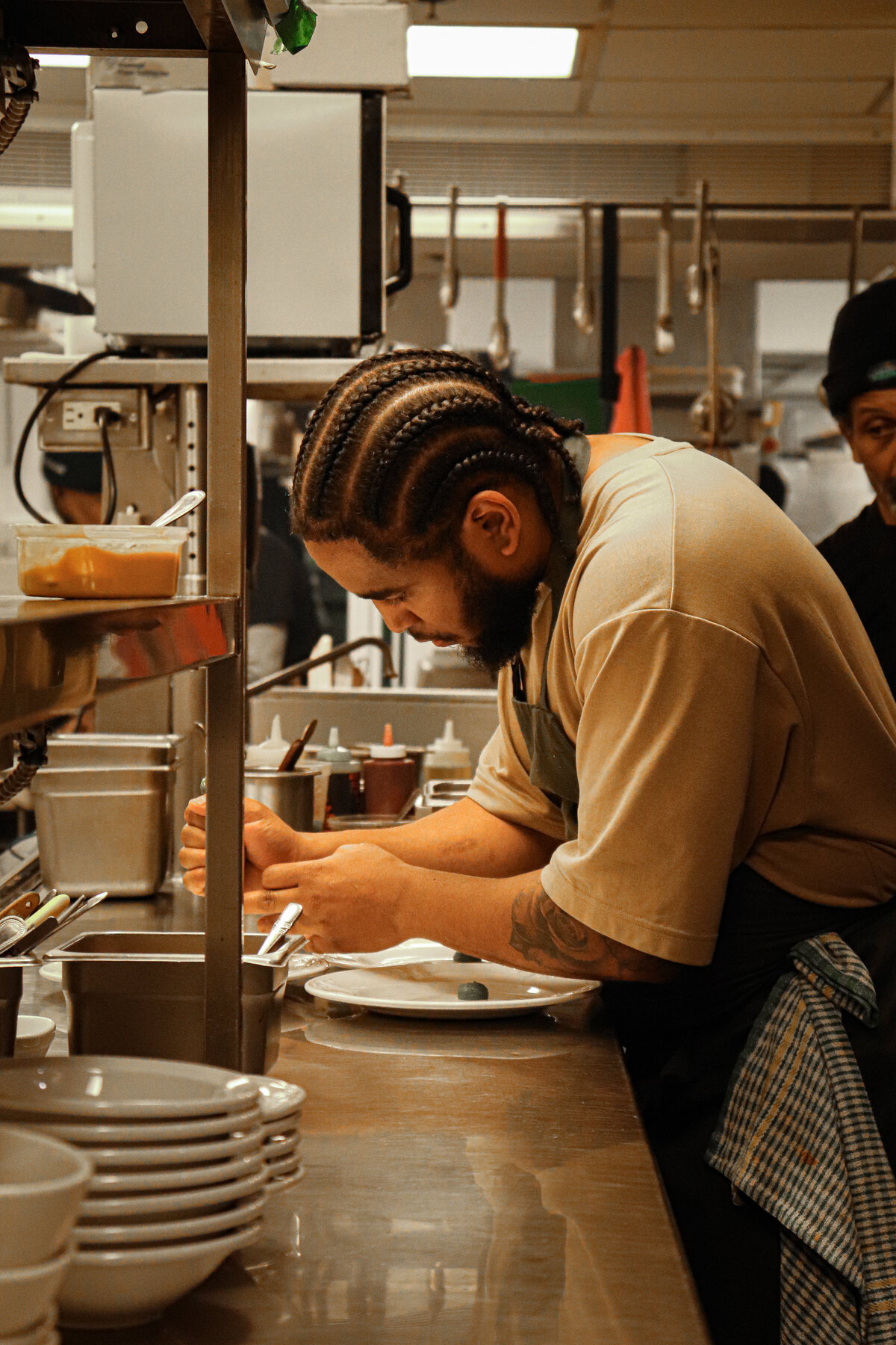 a man in a restaurant kitchen plating food
