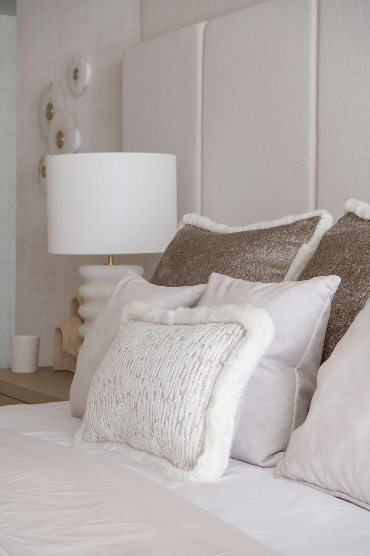 A close look at the neutral throw pillows atop the soft white bed in the primary bedroom.