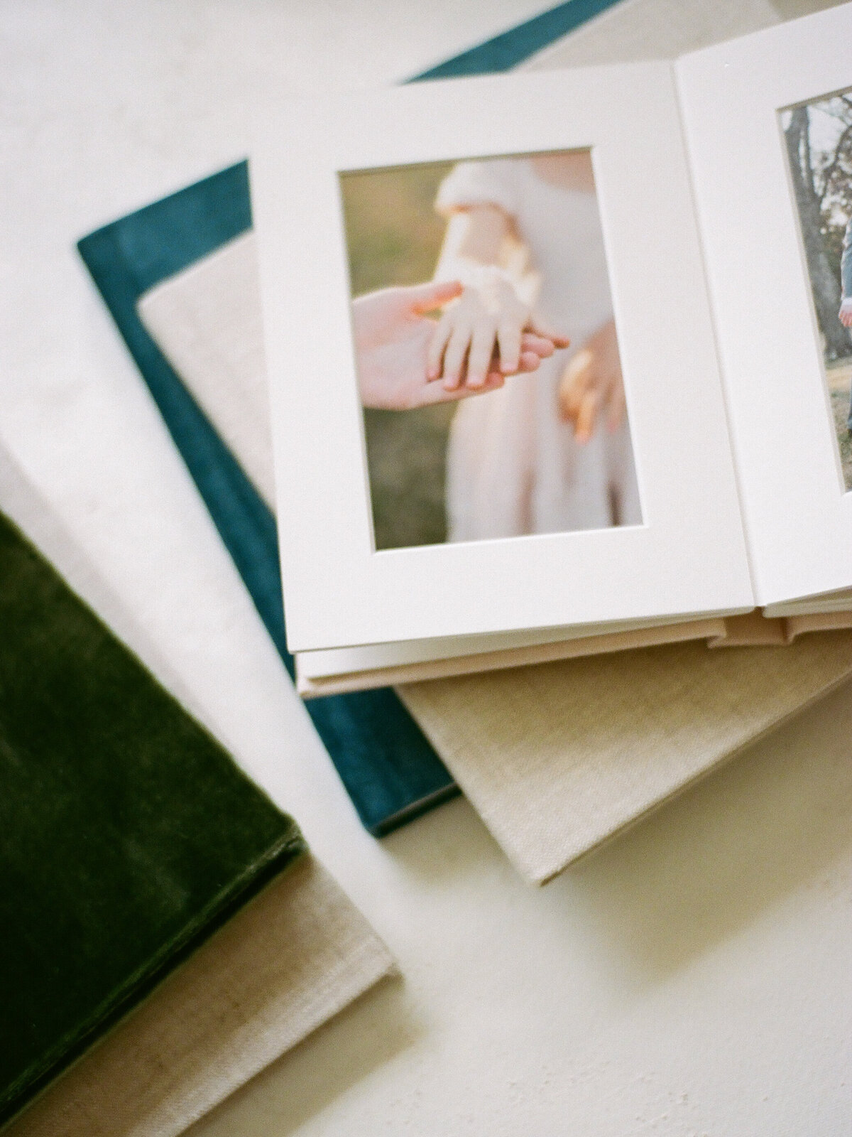 pink linen matted album on stack of family albums