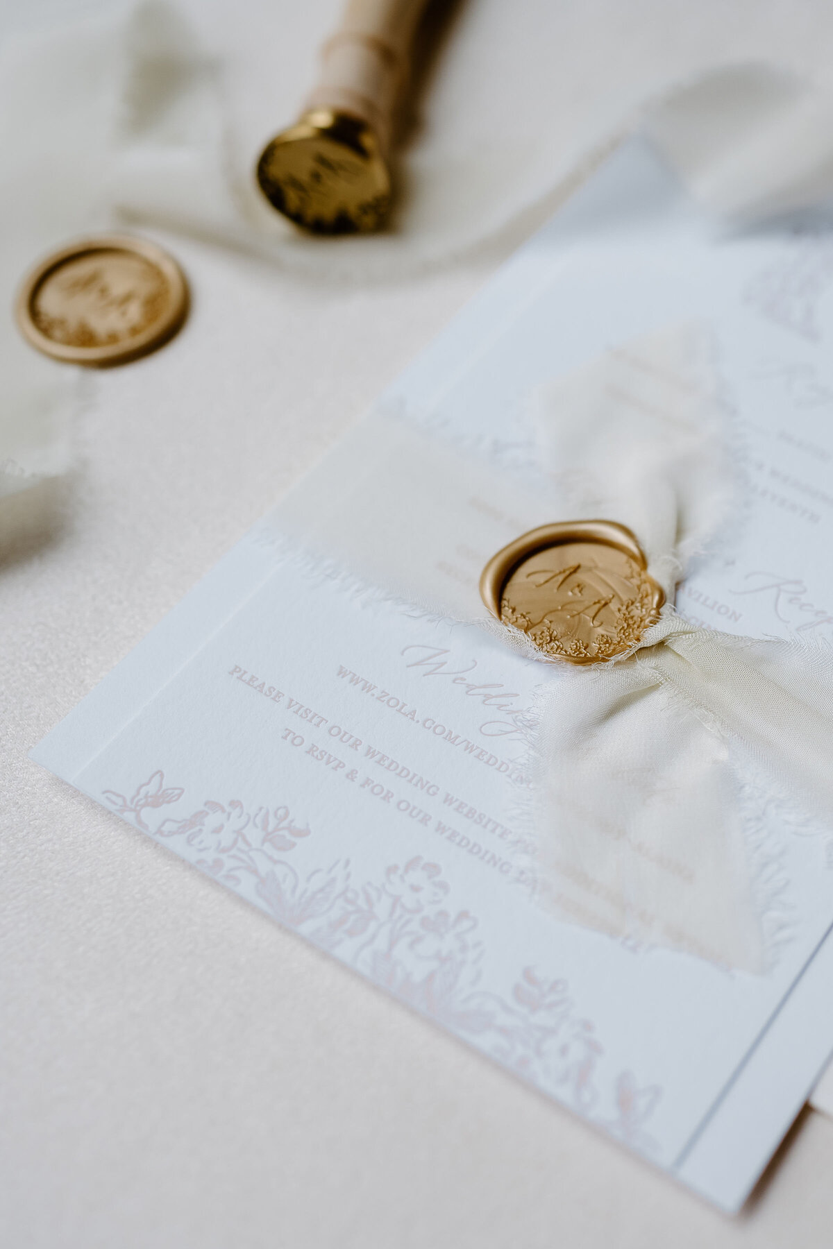 Luxury wedding invitation with gold wax seal and silk ribbon.