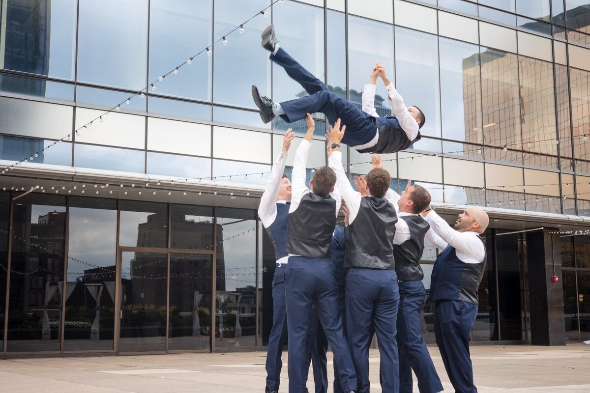 groomsmen-throwing-groom-rooftop-jps-events.jpg