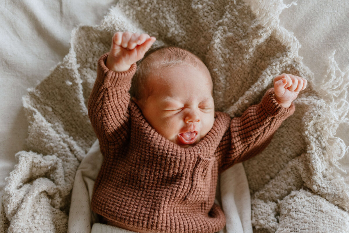 Photo of a baby yawning and stretching