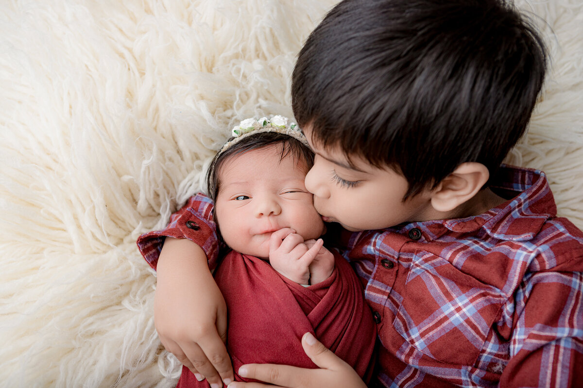 Newborn sister and older brother flokati pose