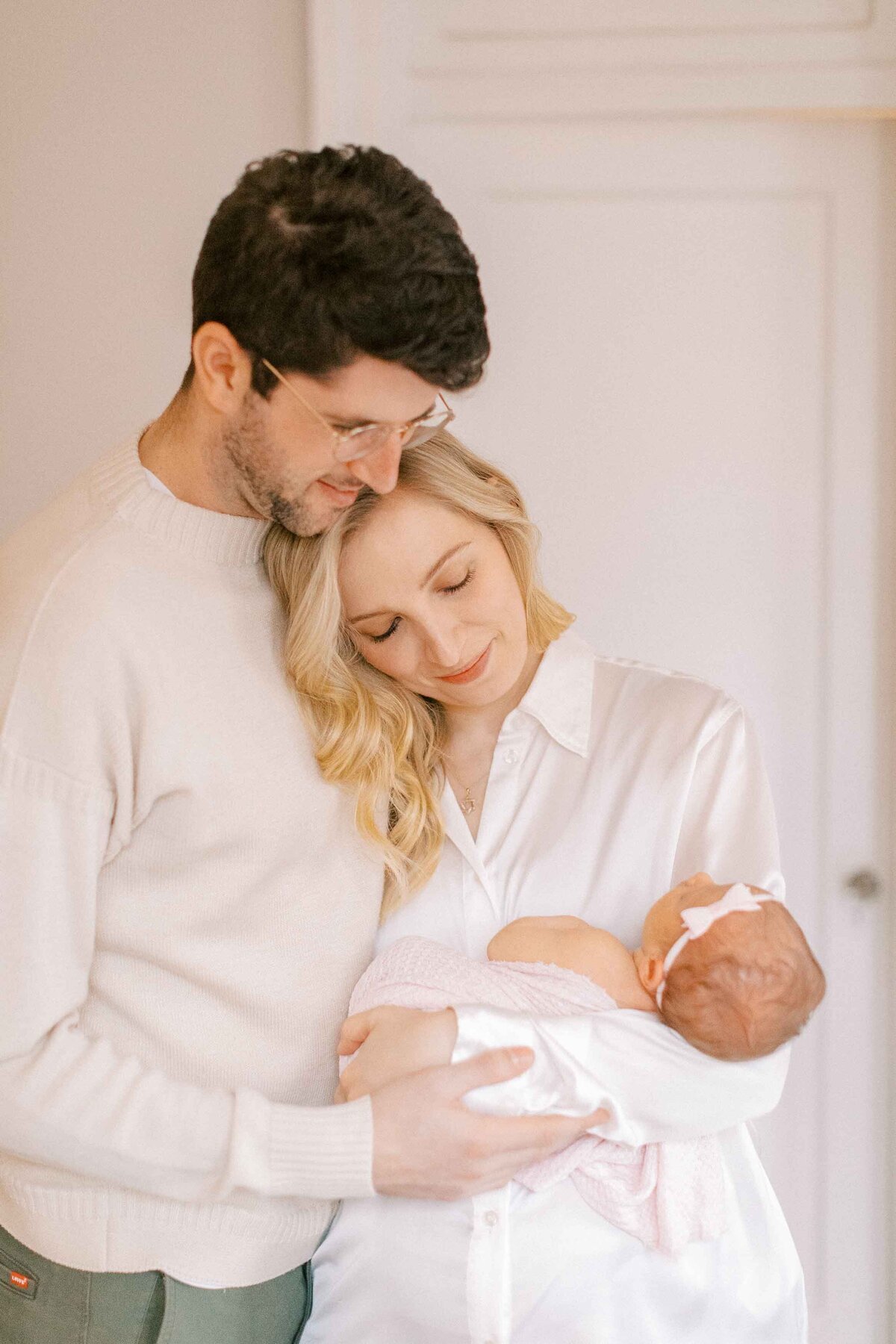 new mom and dad snuggling their baby girl