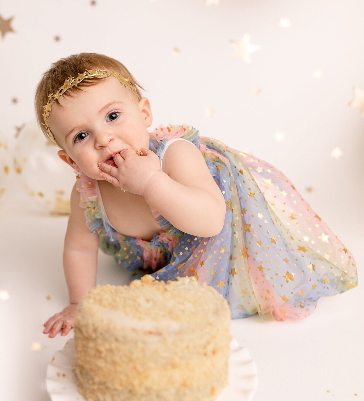 Baby eating cake in pdx studio for first birthday