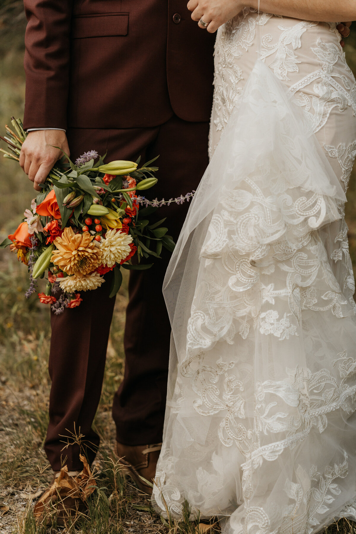 a close up of someone holding a bouquet of flowers with their partner standing next to them 