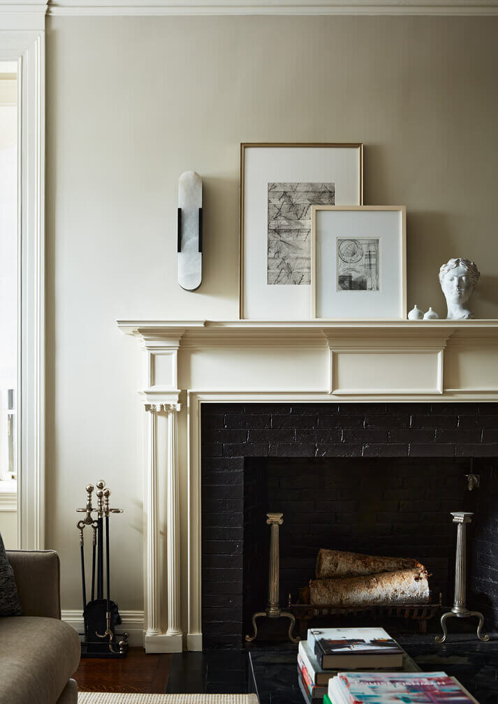 A historic fireplace is the focal point of this old home design by a Boston area interior designer, blending traditional details with modern updates.