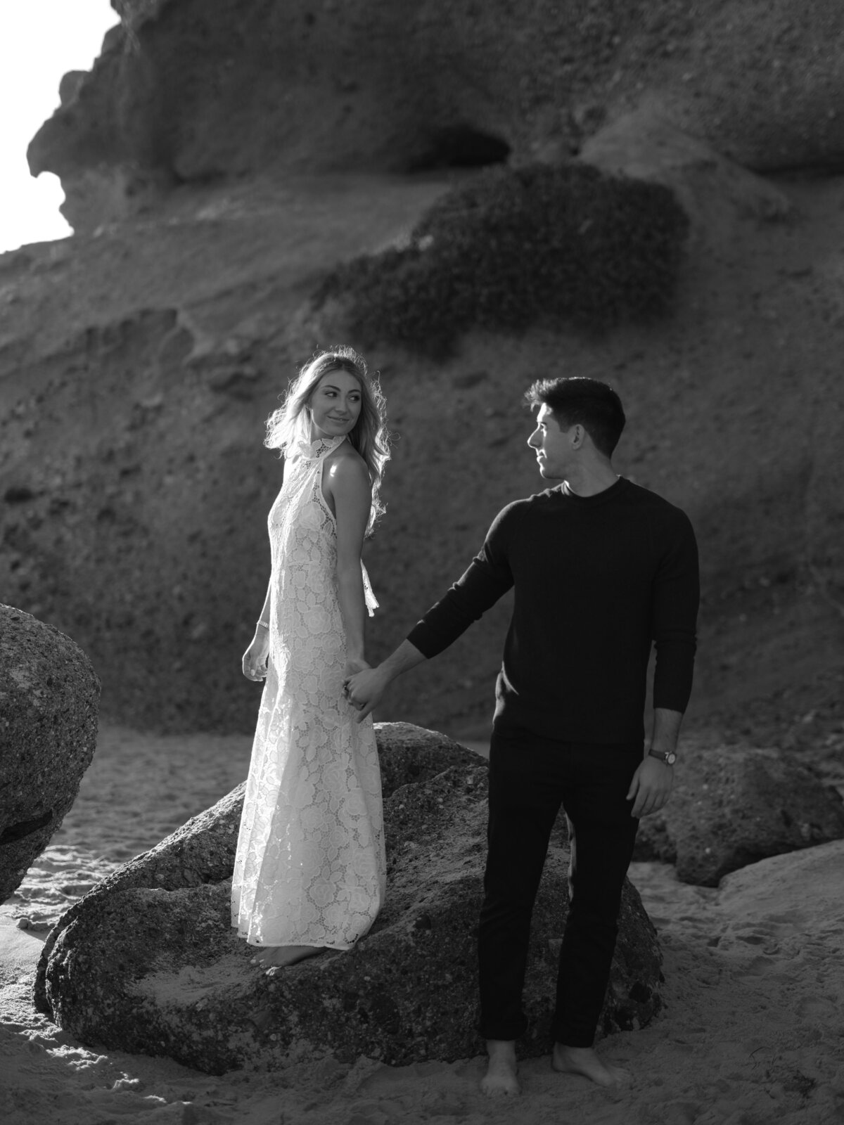 Couple standing on rock in Laguna Beach