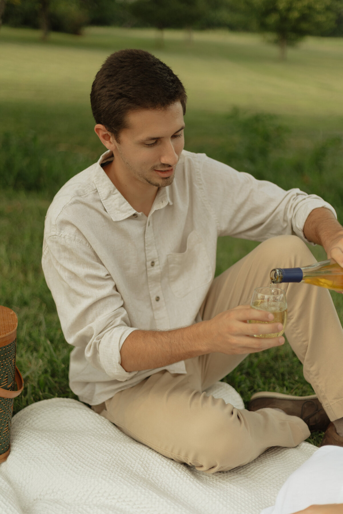 Couple enjoying a cozy picnic with wine and charcuterie at a tropical vineyard


