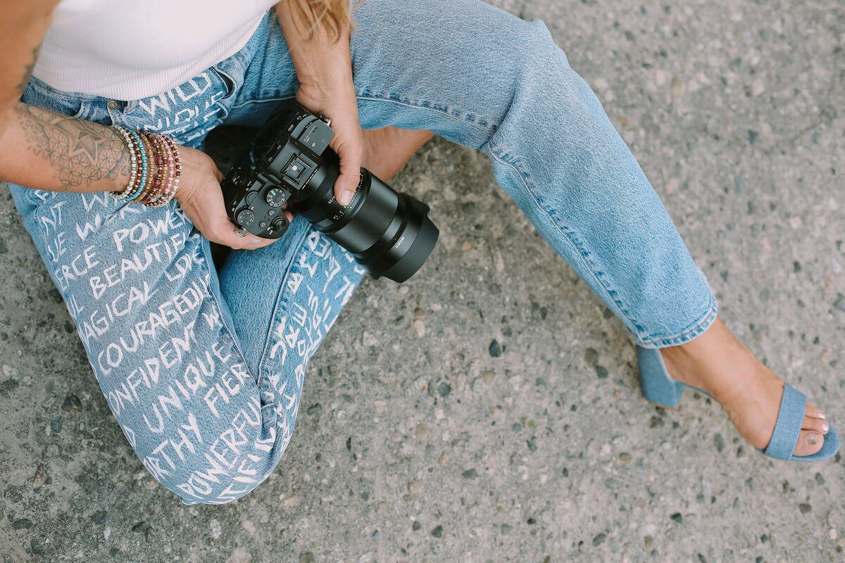 lit candle surrounded by printed photographs of women for brand photography photoshoot