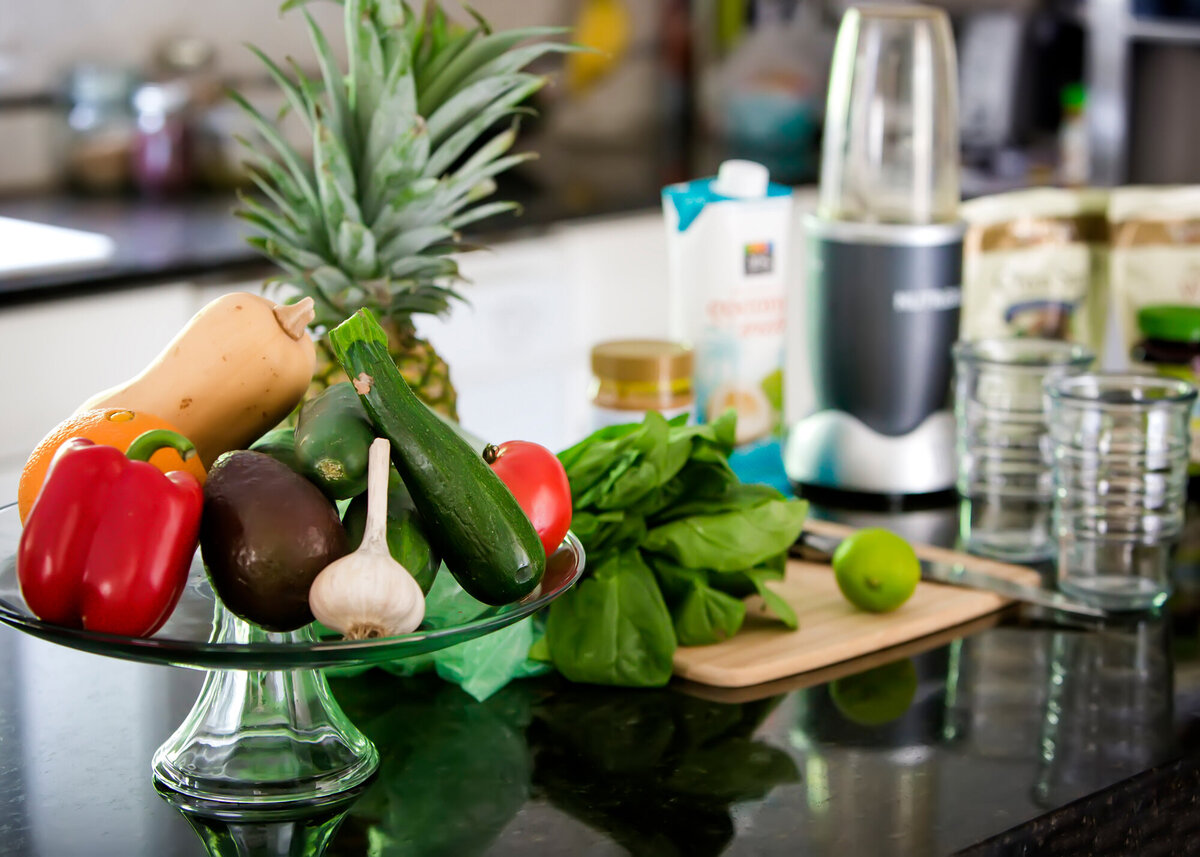 A kitchen island with fresh vegetables displayed, a cutting board, and a NutraBullet taken by a South Shore MA branding photographer
