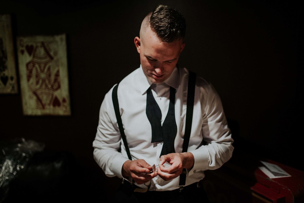 Groom opens cuff links in Canal 337 getting ready room.