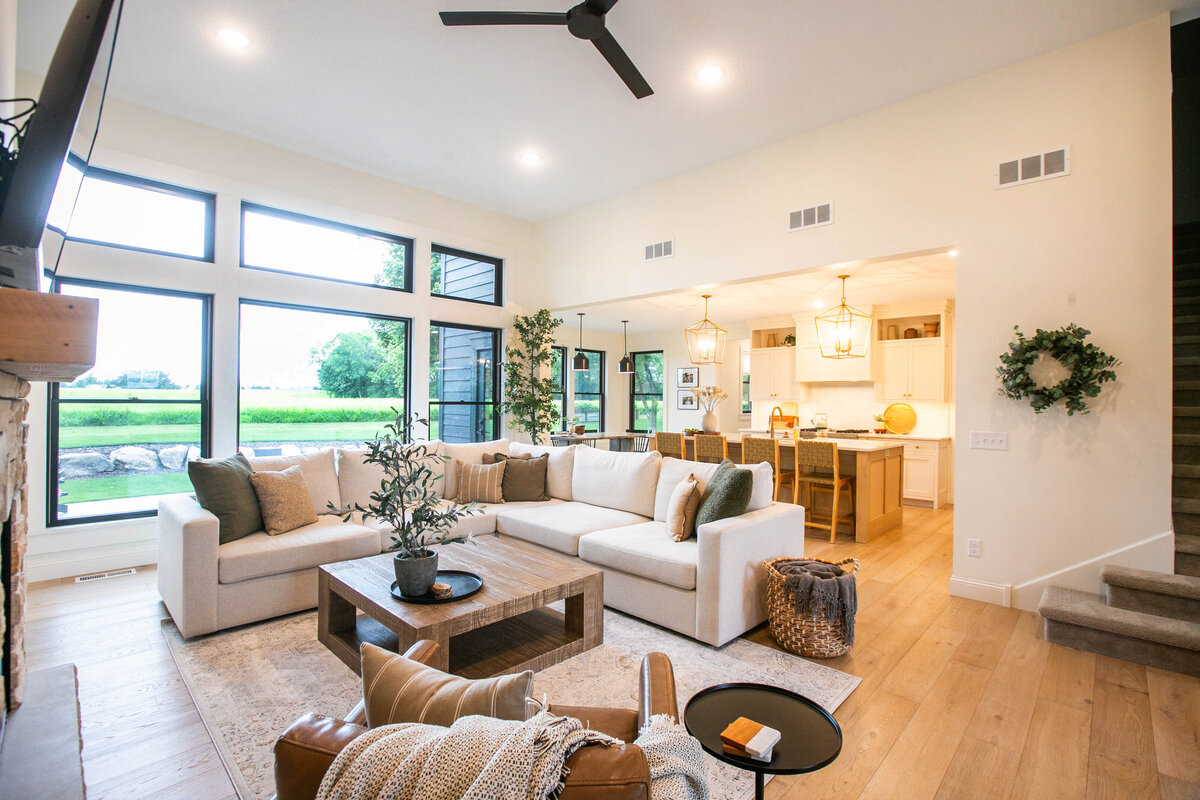 Cozy living room in Otsego custom home with fireplace, built-ins, and large windows