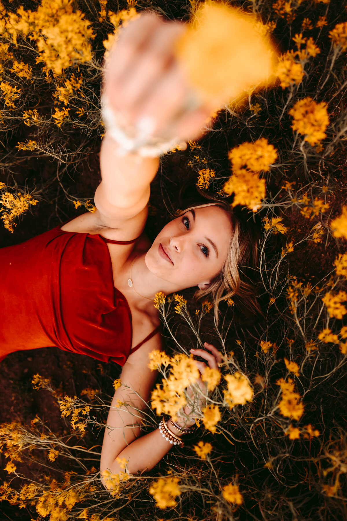Jordan lays in a field of flowers for her Telluride senior pictures.