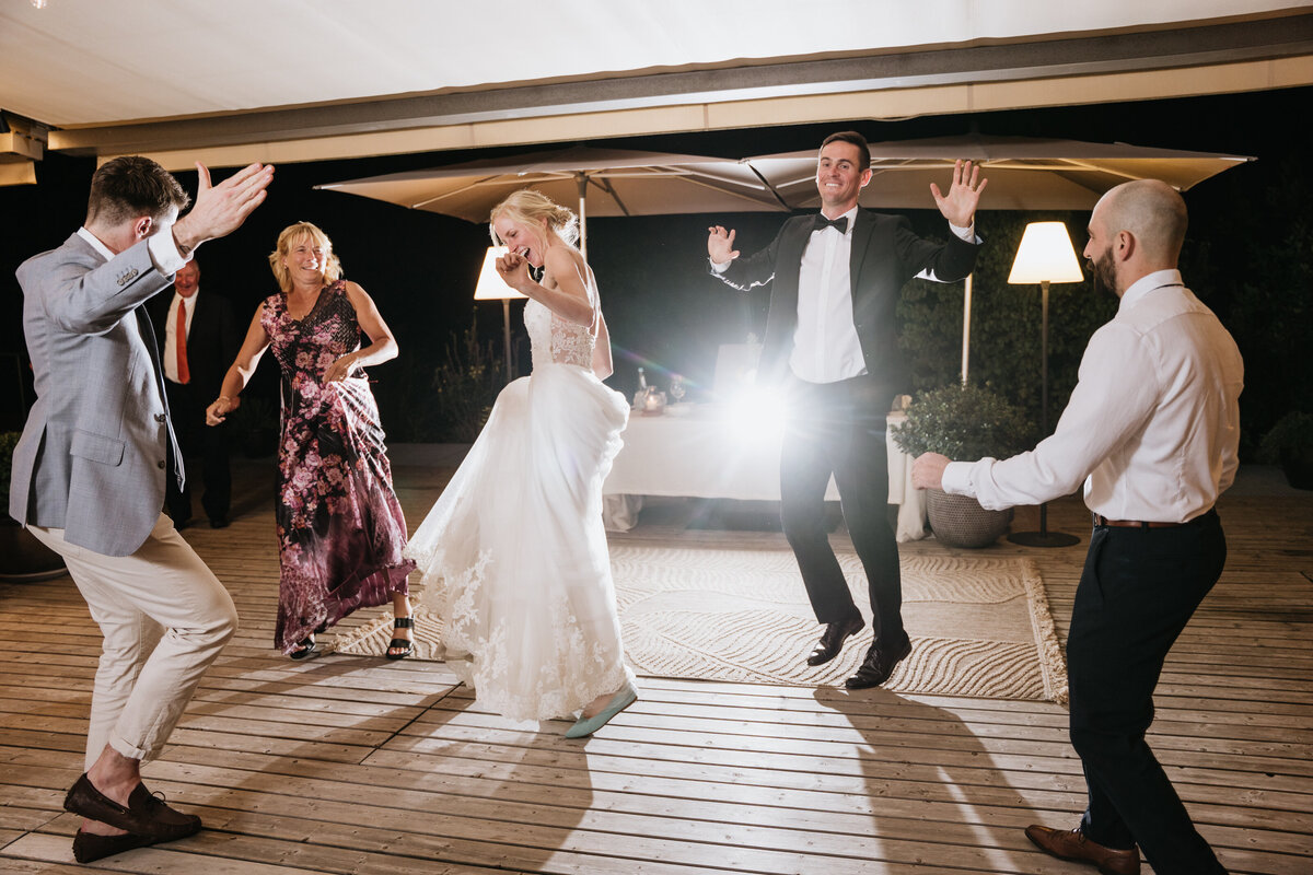 Wedding guests dancing energetically outdoors