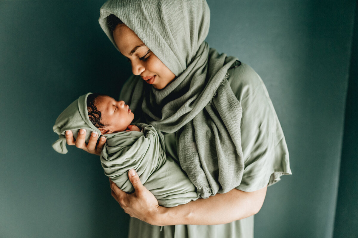 Newborn photographer capturing mom holding infant babe